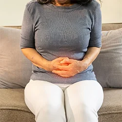 Woman experiencing symptoms of Inflammatory Bowel Disease IBD